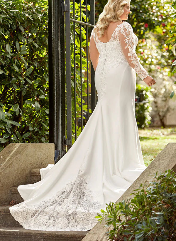 Back view of a model wearing a plus size mermaid wedding dress, showcasing lace applique details and long sleeves.