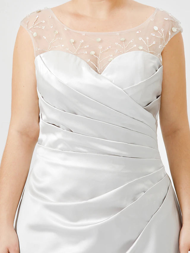 Close-up of the jewel neck and crystal embellishments on a satin dress.