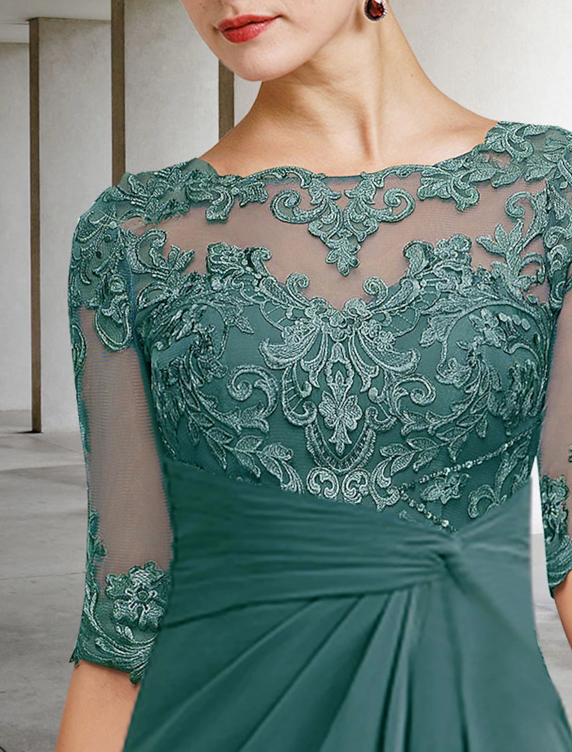 Close-up of the jewel neck and short sleeve detail on the elegant dress.