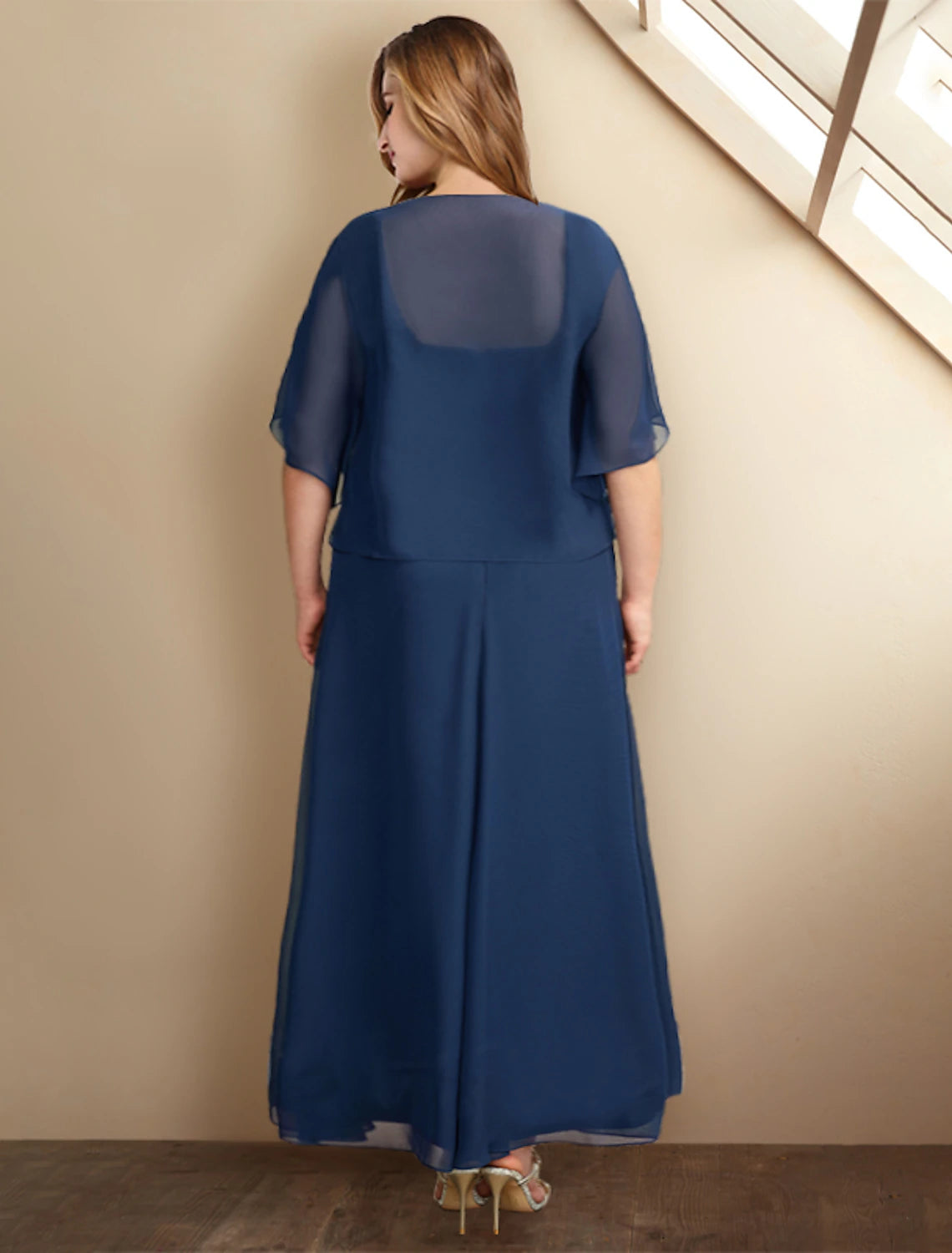 Back view of the elegant plus size A-line chiffon dress, showing flowing skirt.