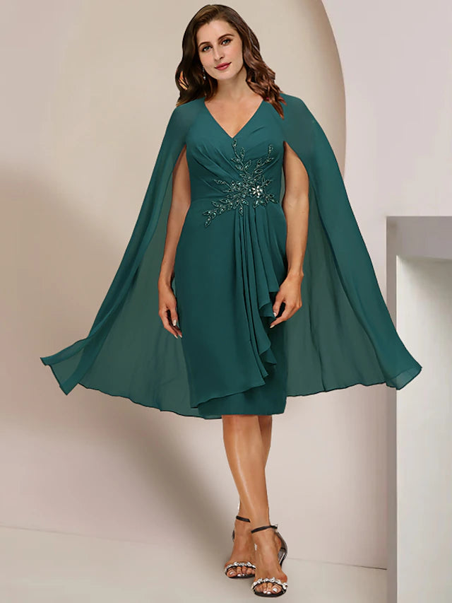 Woman wearing an elegant plus size V-neck knee-length chiffon dress with pleats and crystal beading.