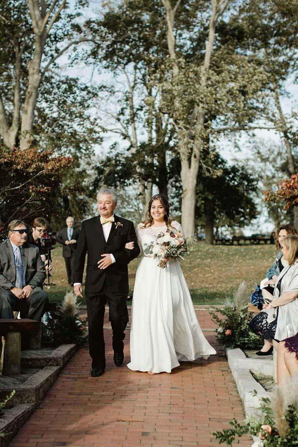 Plus size ivory wedding dress with lace top, V-neck, and long sleeves.