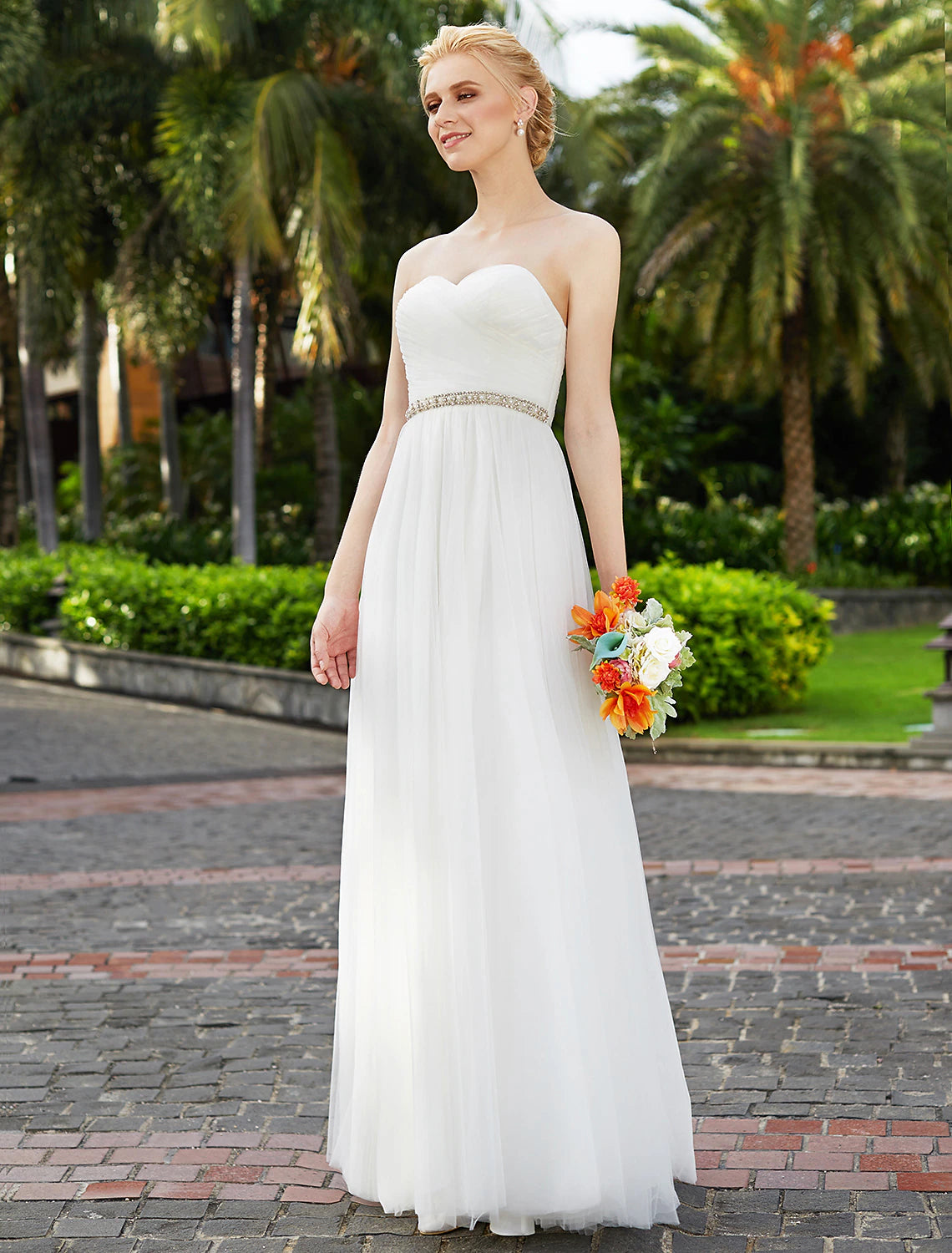 Side view of a strapless floor length reception dress.
