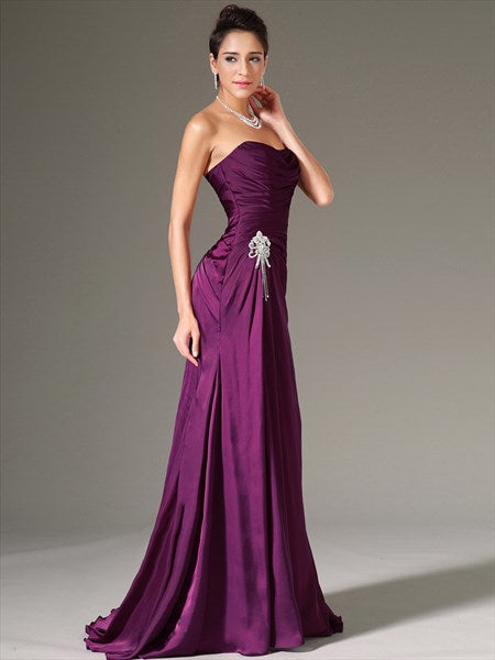 Front view of a woman in a purple strapless sheath prom dress, highlighting the ruched bodice.