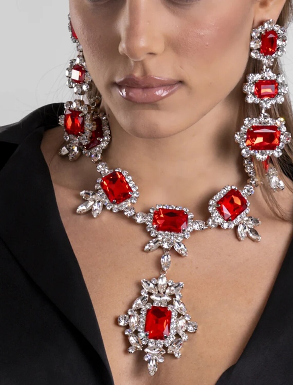 Woman wearing an elegant rhinestone necklace and matching earrings.