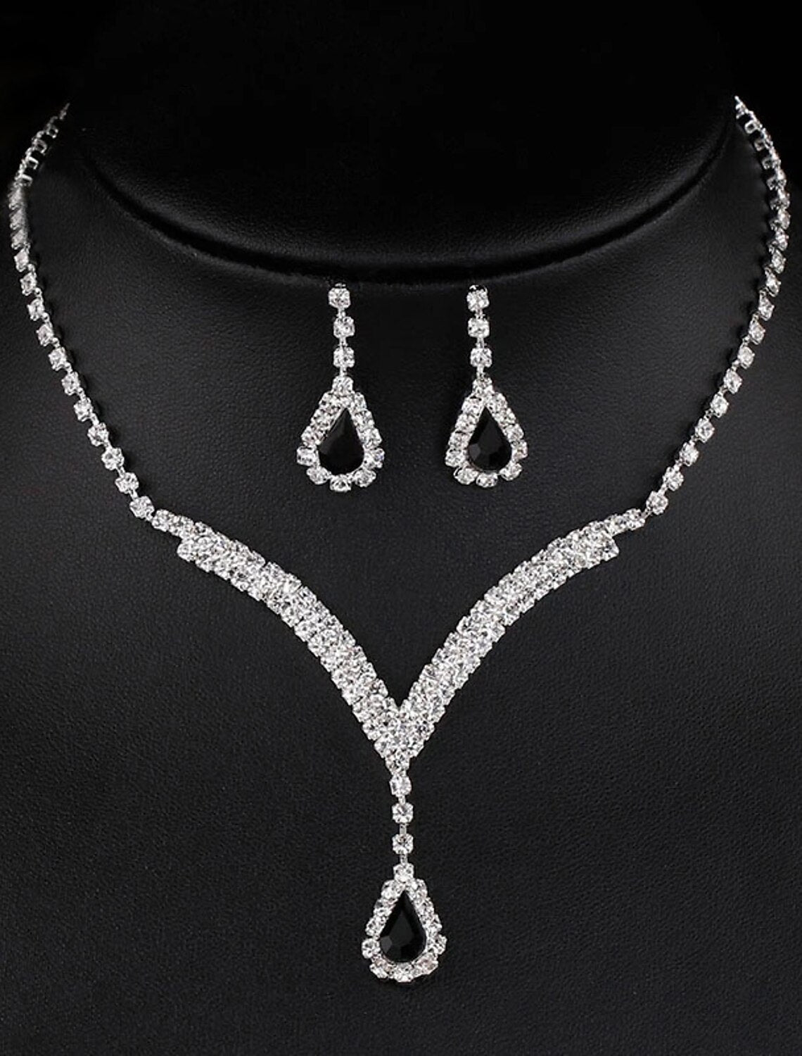 Close-up of a woman wearing rhinestone chandelier drop earrings.