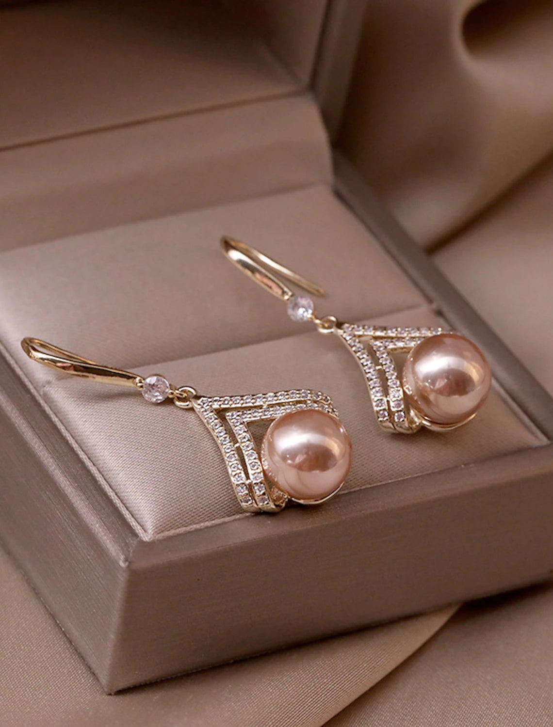 Close-up of a single rose gold pearl stud earring.