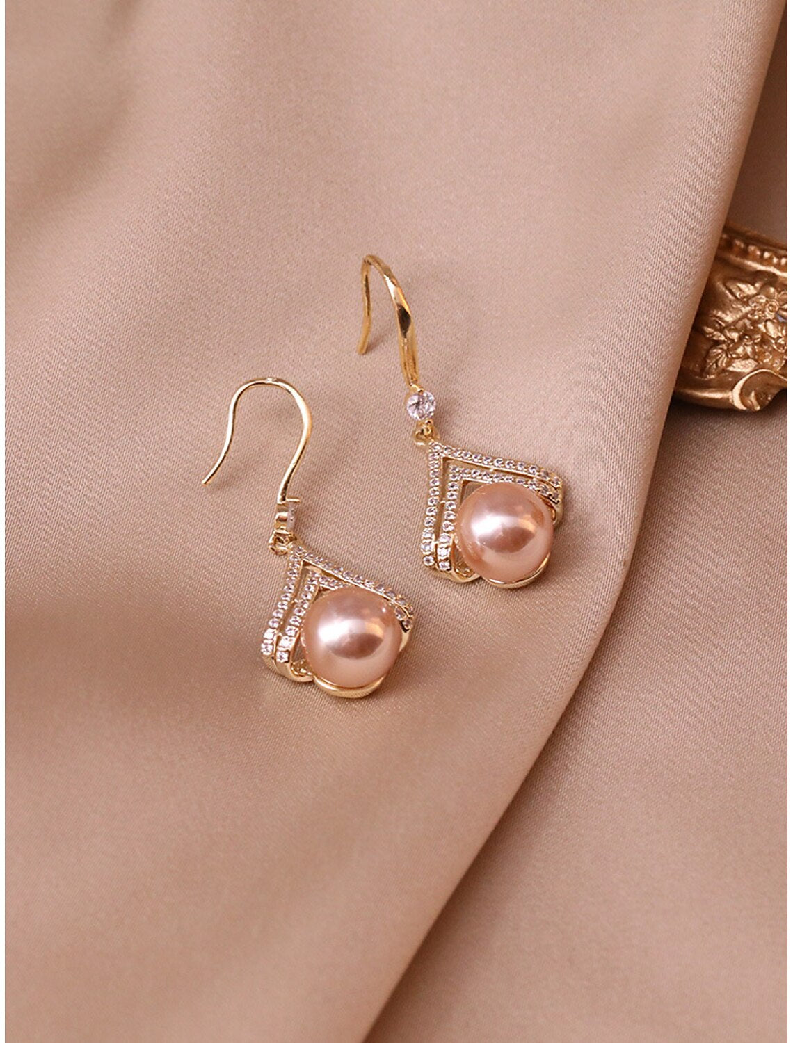 Pair of elegant rose gold pearl stud earrings.