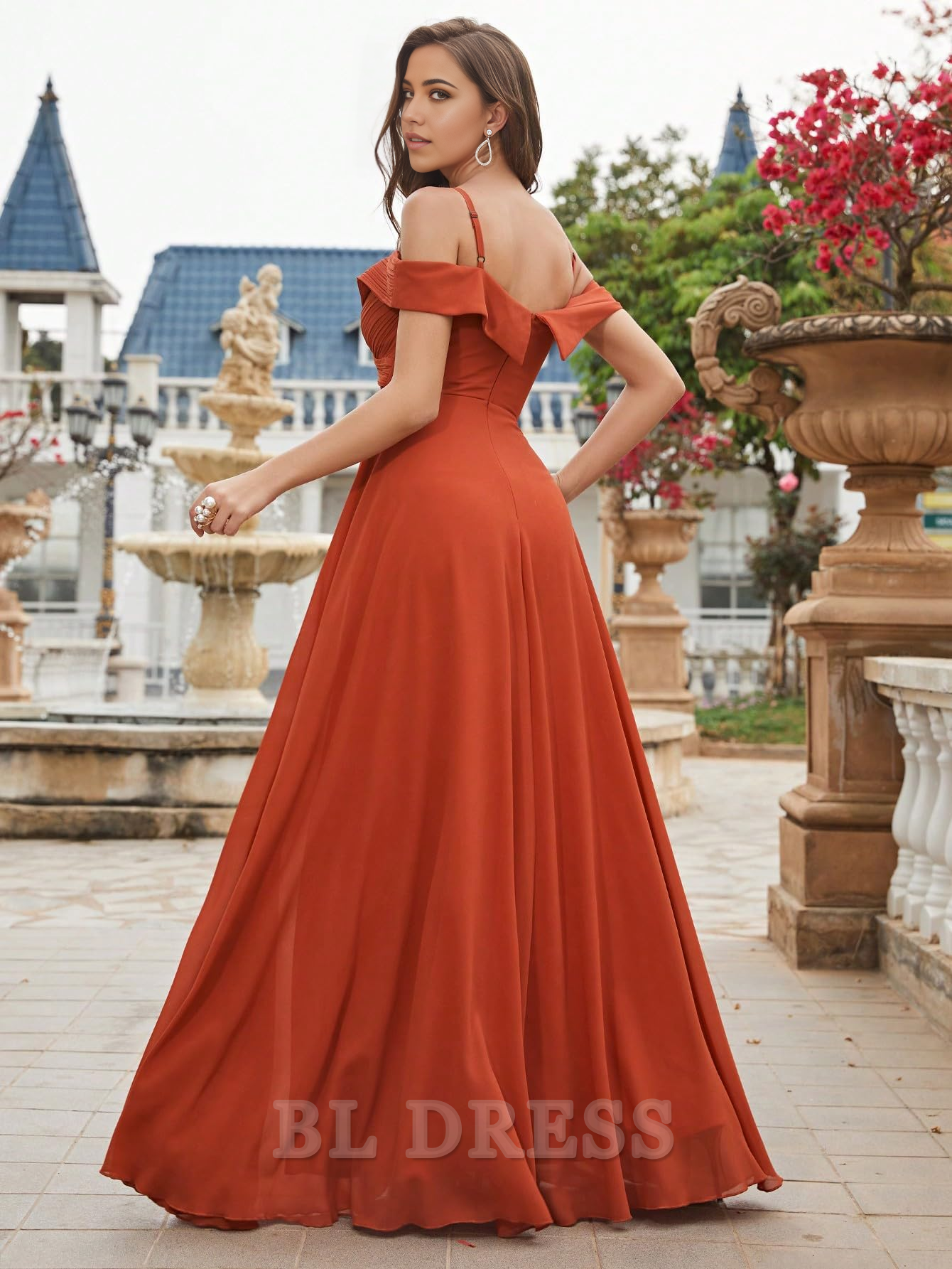 Back view of a woman wearing an elegant cold shoulder ruched chiffon dress.