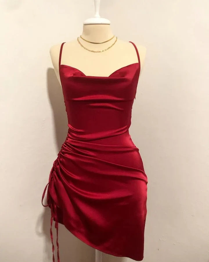 Red ruched satin sheath dress with cowl neck and spaghetti straps.