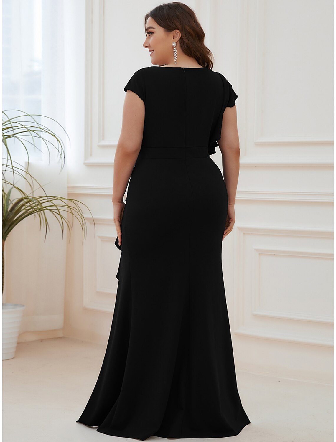 Side view of the floor-length mermaid trumpet dress with ruffles and slit.