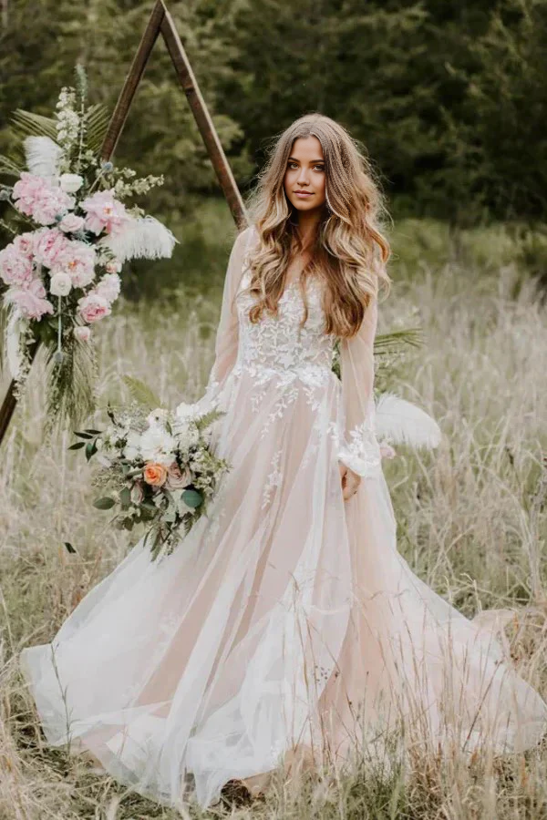 Woman wearing an elegant rustic A-line V-neck long sleeve wedding gown.