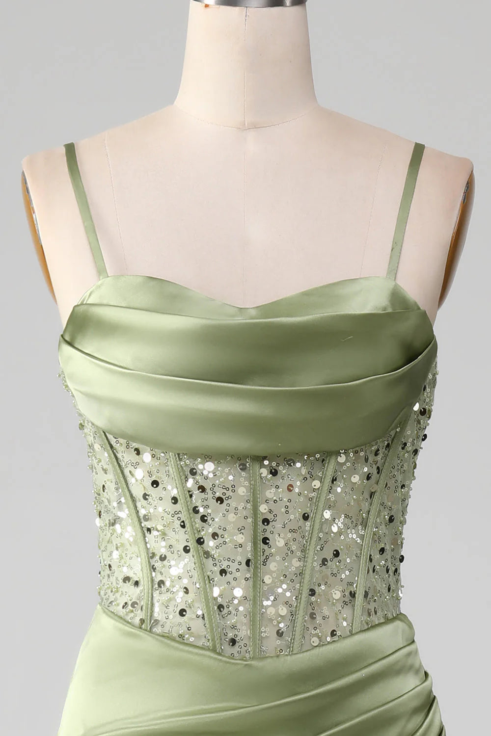 Close-up of corset bodice and thigh-high split on sage prom dress.