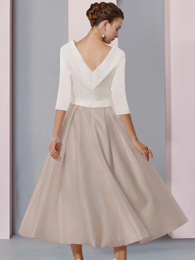 Close-up of the color block detail and pleats on the elegant satin dress.