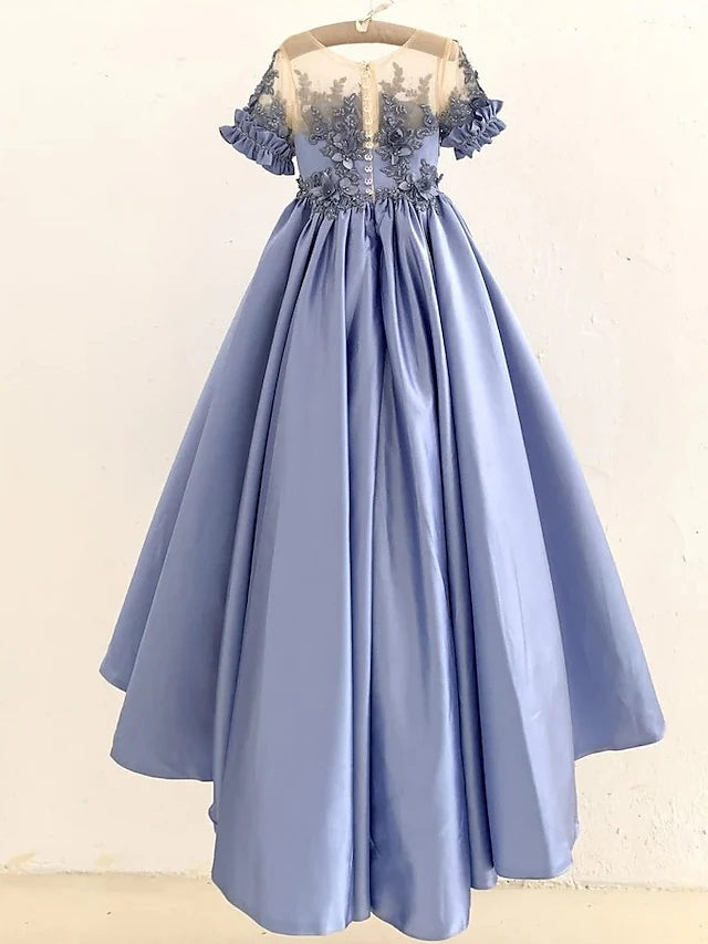 Close-up of the elegant white satin ball gown with intricate appliques.