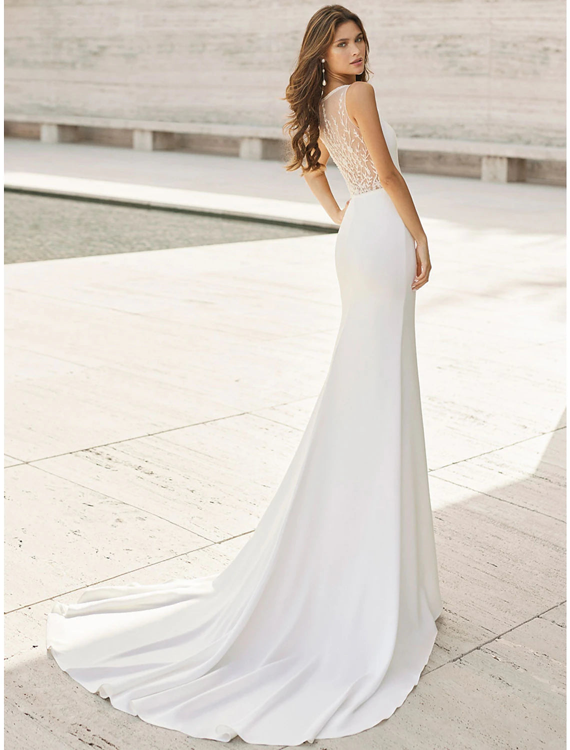 Back view of a satin mermaid wedding dress showing appliques and court train.