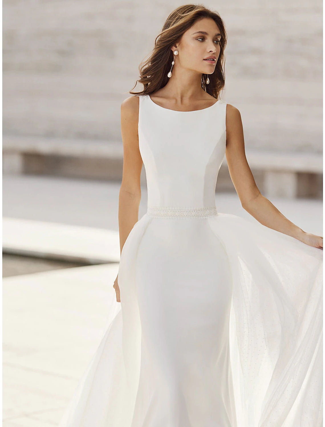Front view of a white satin mermaid wedding dress with delicate appliques.