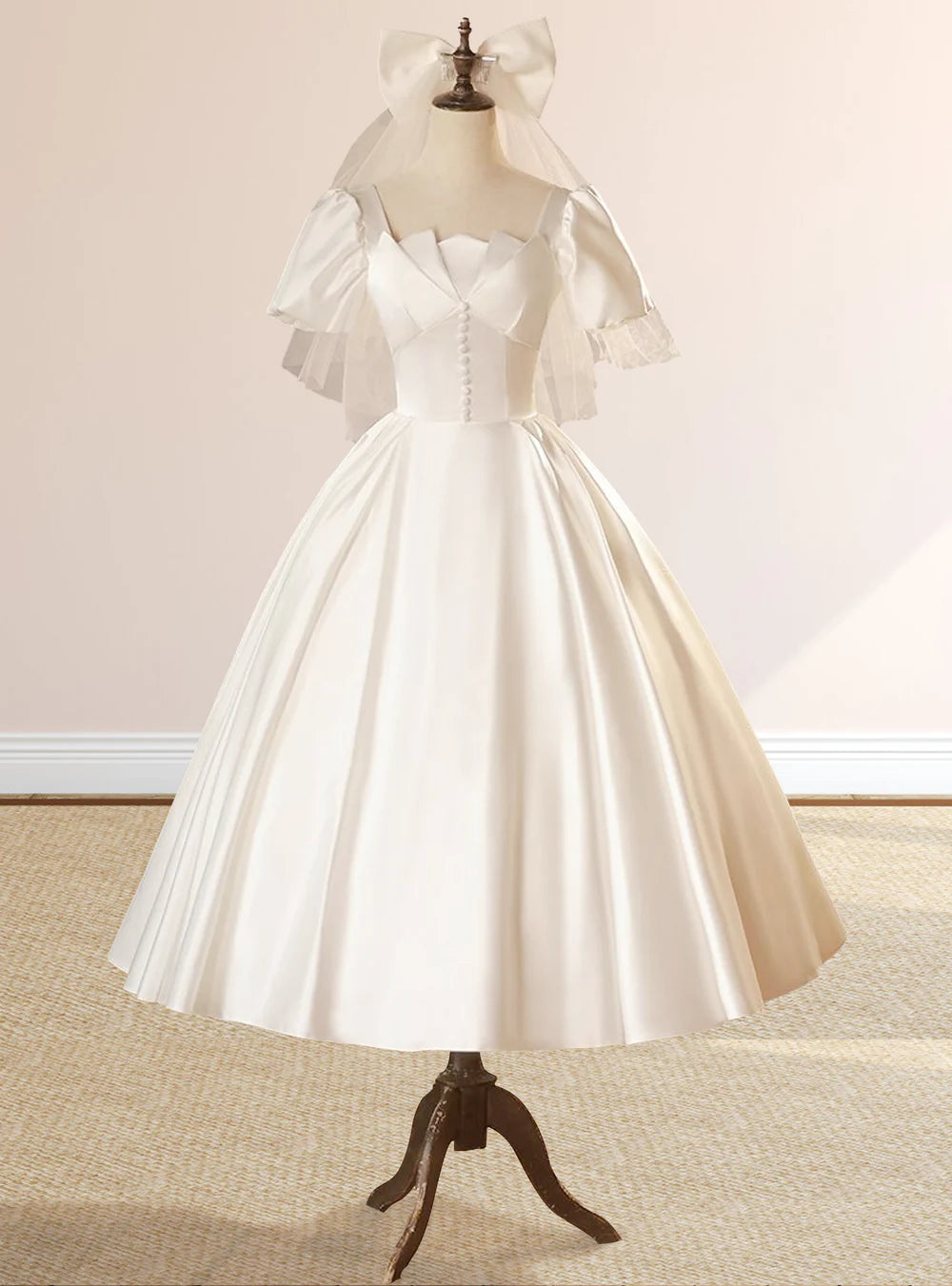 Full-length view of an elegant white satin square neck short sleeve wedding dress with a lace-up back.