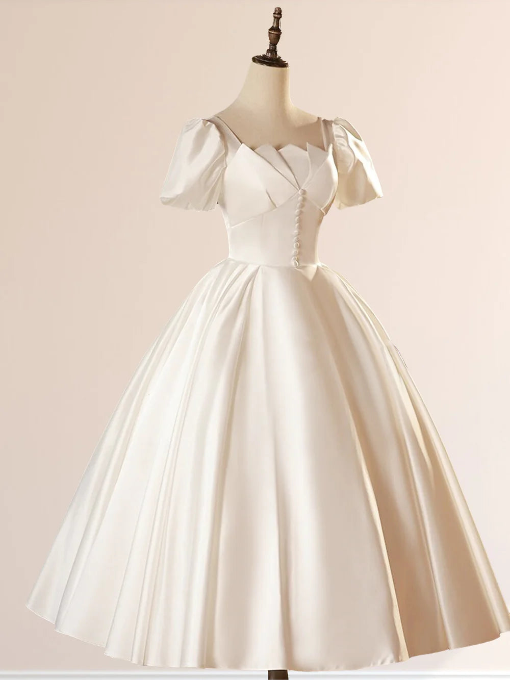 Close-up of the square neckline and short sleeves of the satin wedding dress.