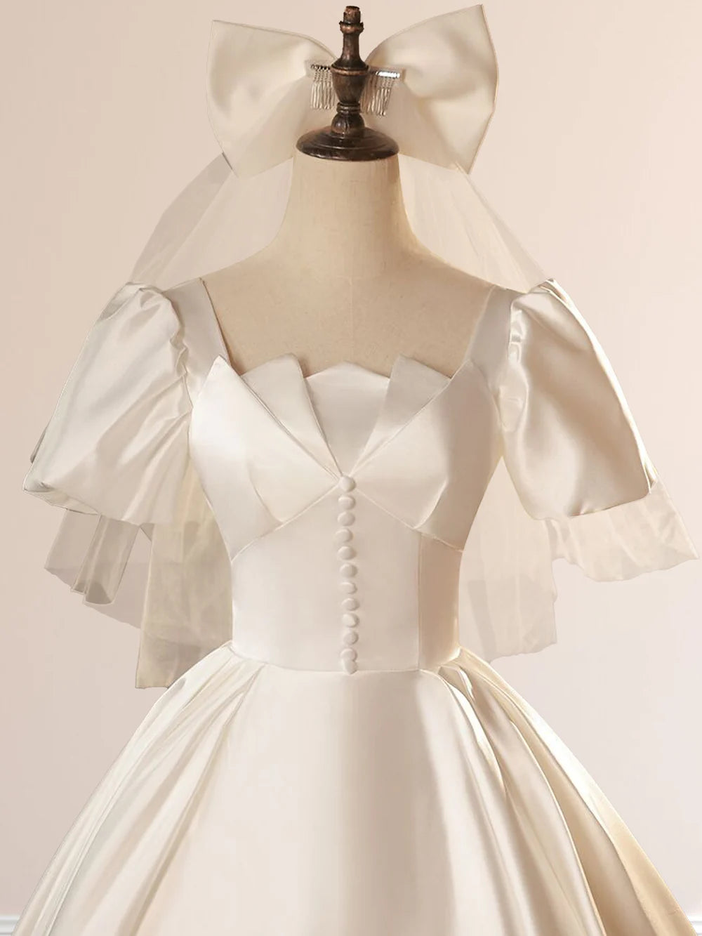 Back view of the white satin wedding dress, showing the intricate lace-up detail.