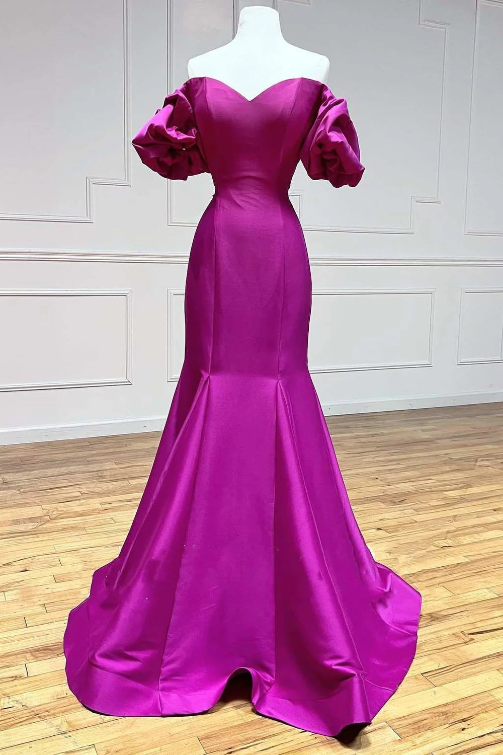 Woman wearing an elegant strapless satin trumpet long prom dress, posing gracefully.