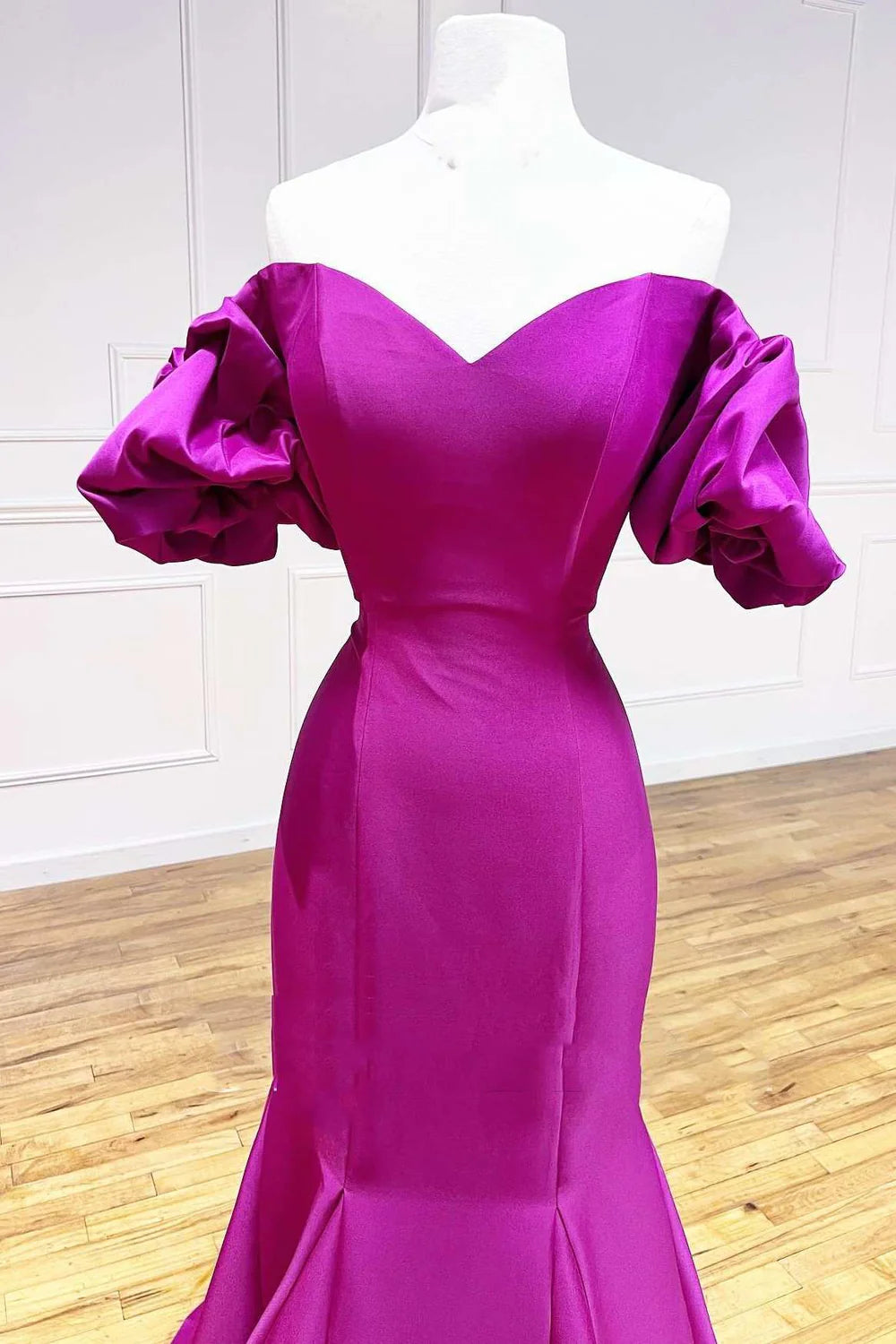 Side profile of a woman showcasing the flowing trumpet skirt of a satin long dress.