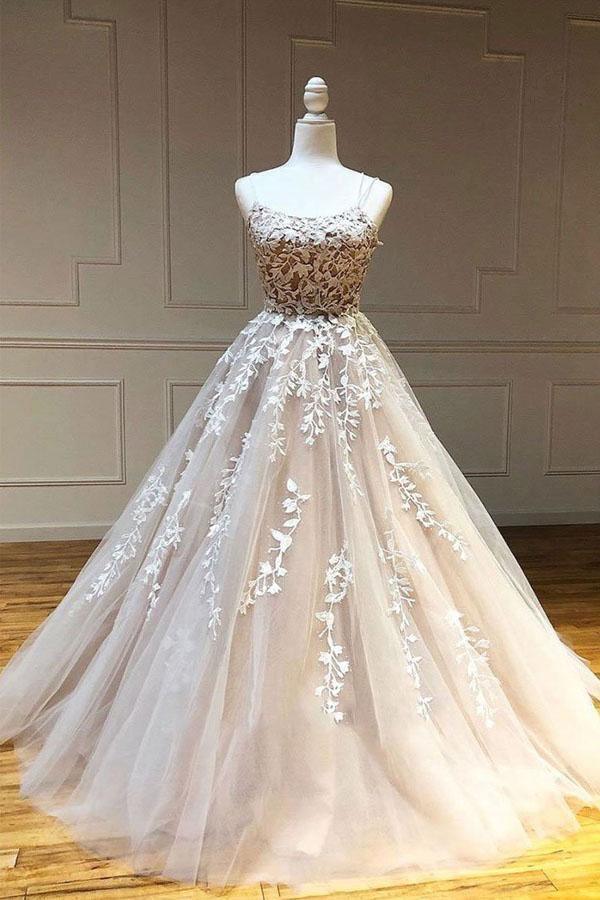 Woman wearing an elegant long tulle ball gown with scoop neck and lace appliques.