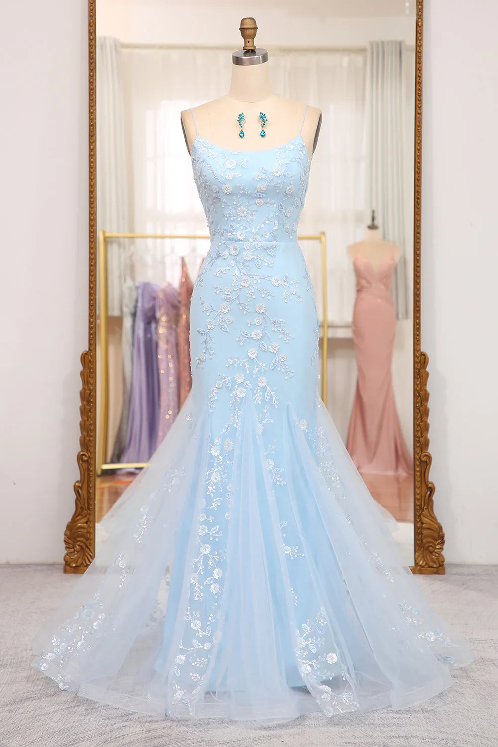Front view of a blue sequin mermaid prom dress with spaghetti straps and a lace-up back.