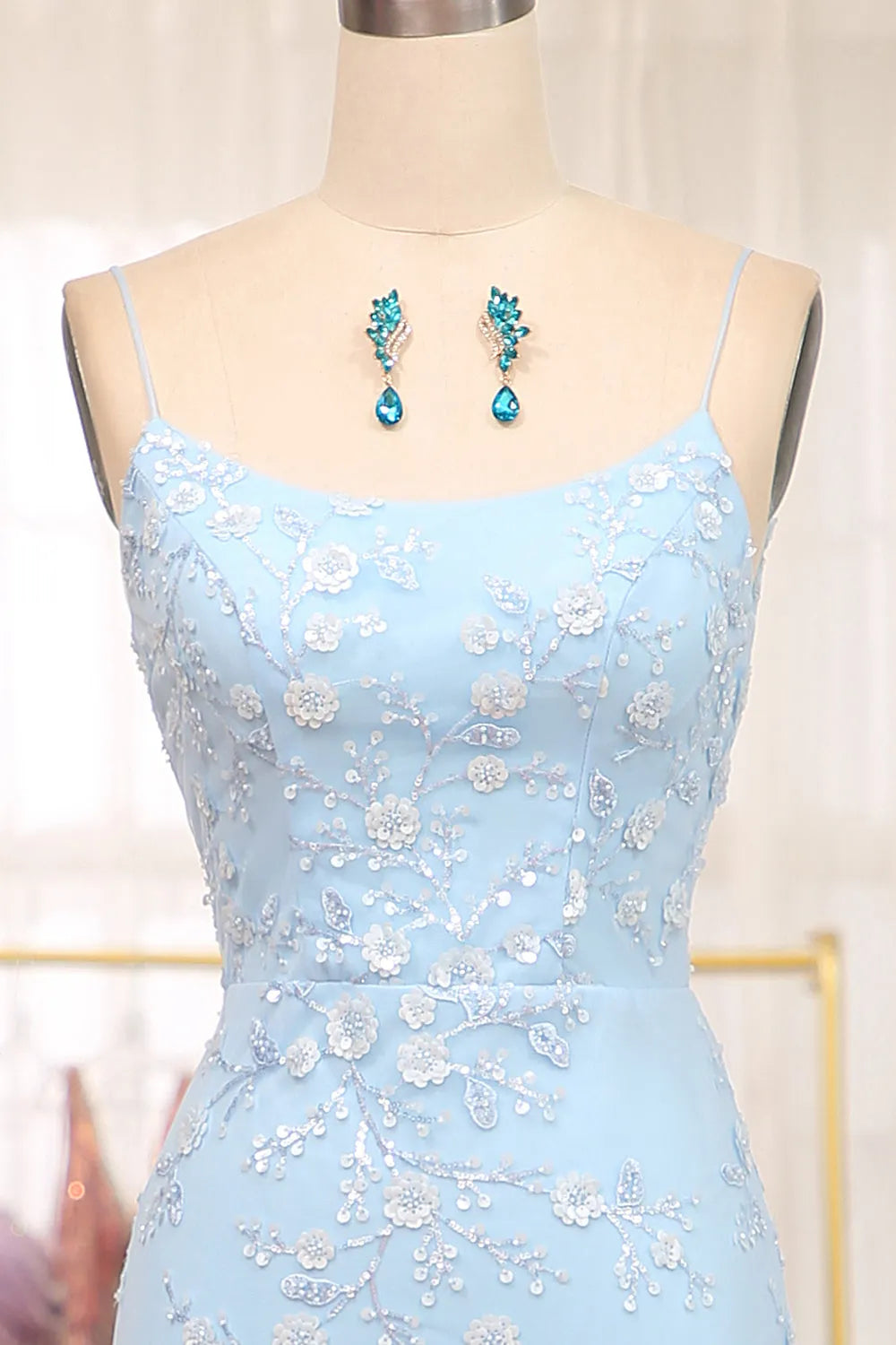 Close-up of the sequin fabric and spaghetti straps on the blue mermaid prom dress.