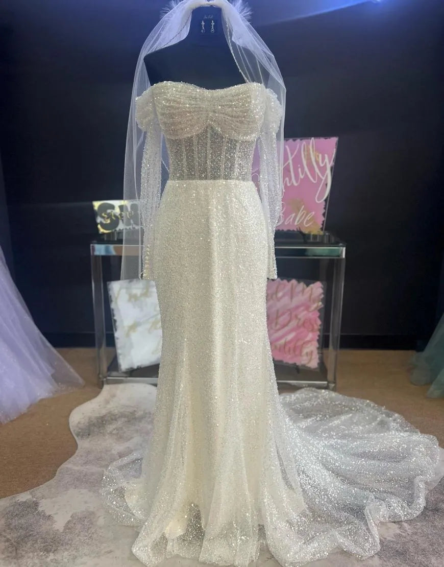 Elegant sequin sheath off-shoulder wedding dress.