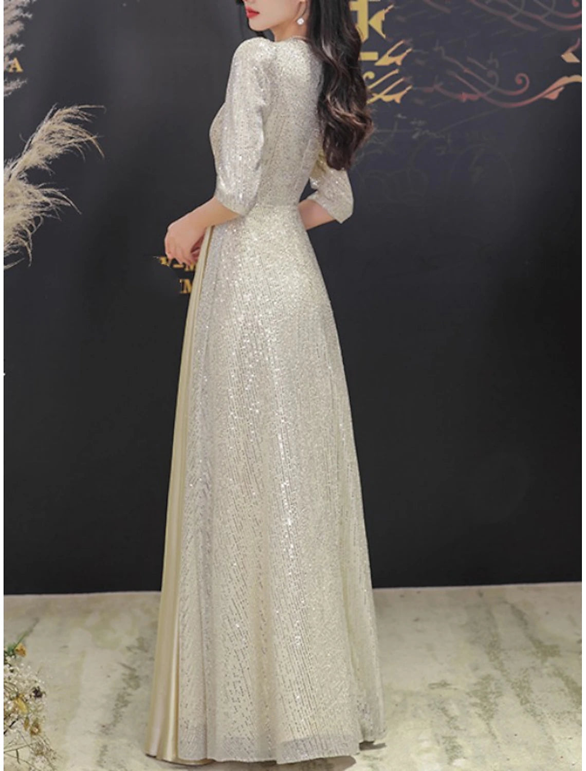 Close-up of the V-neckline and half sleeves on the sequined formal gown.
