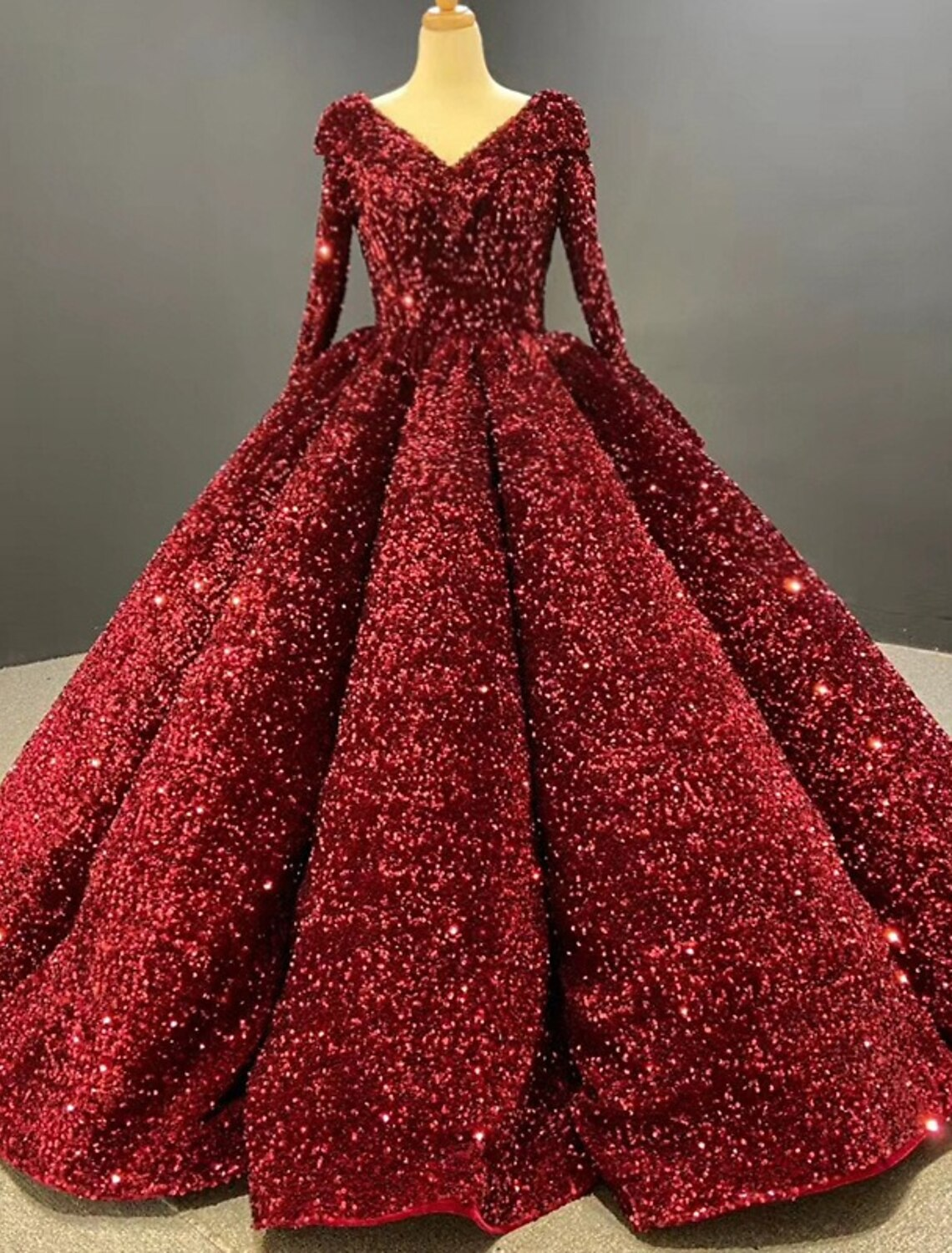 Elegant sequined ball gown prom dress with V-neck and long sleeves.