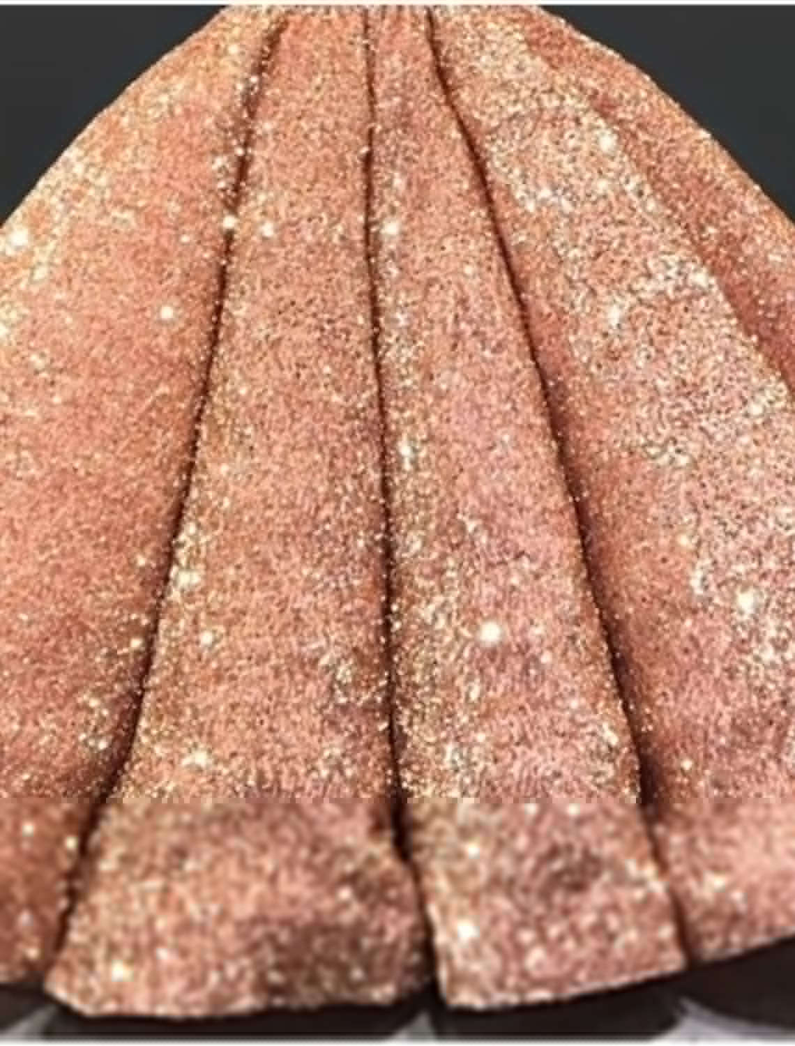 Close-up of sequin and pleated detail on a long sleeve formal dress.