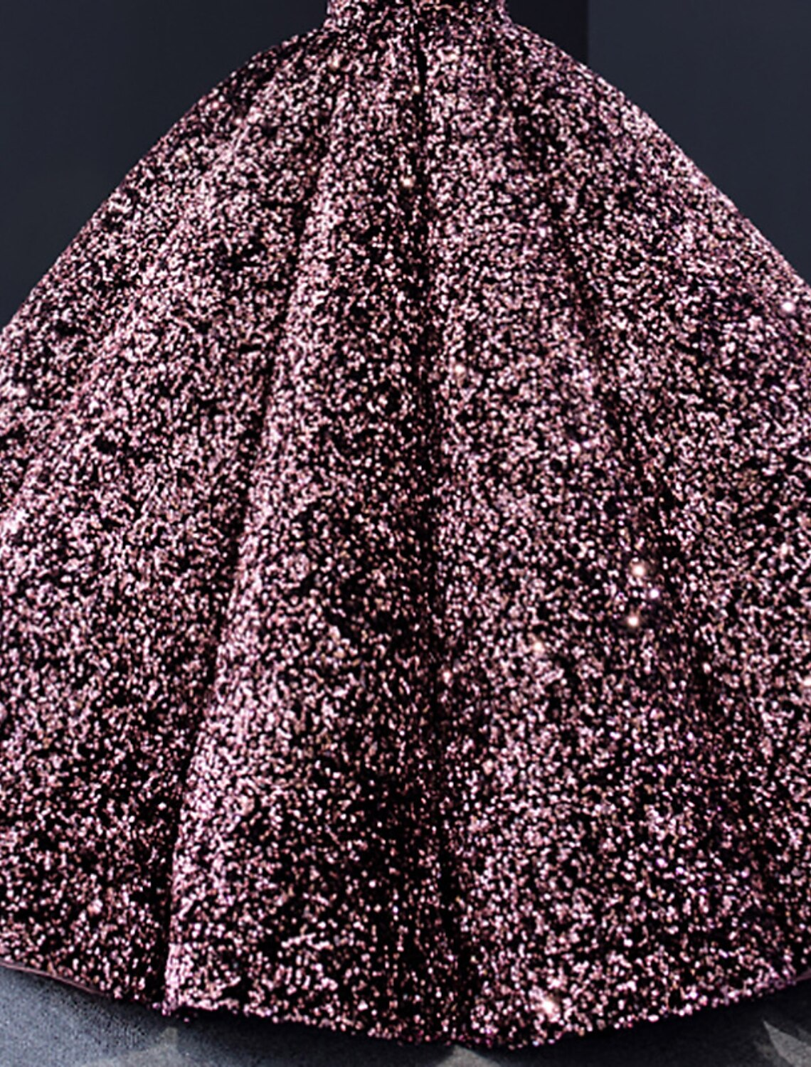 Side view of a woman wearing a V-neck long sleeve sequined ball gown.