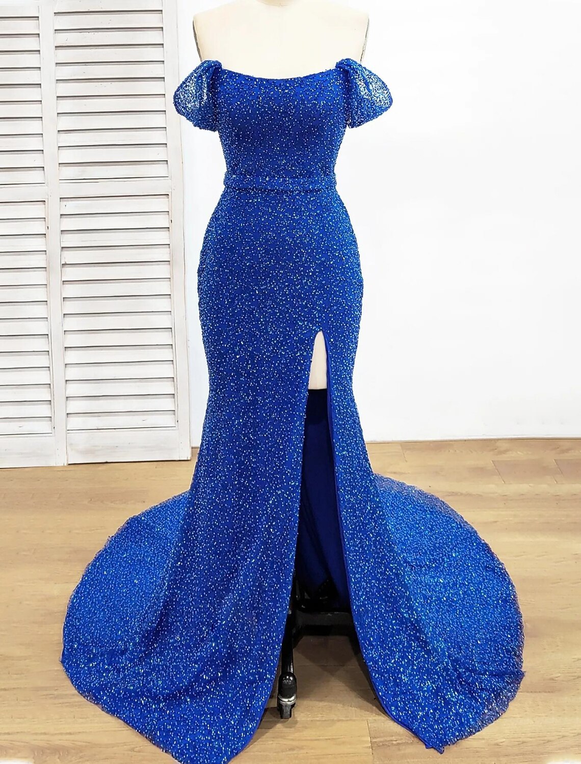 Elegant sequined mermaid trumpet evening gown with off-shoulder neckline and short sleeves.