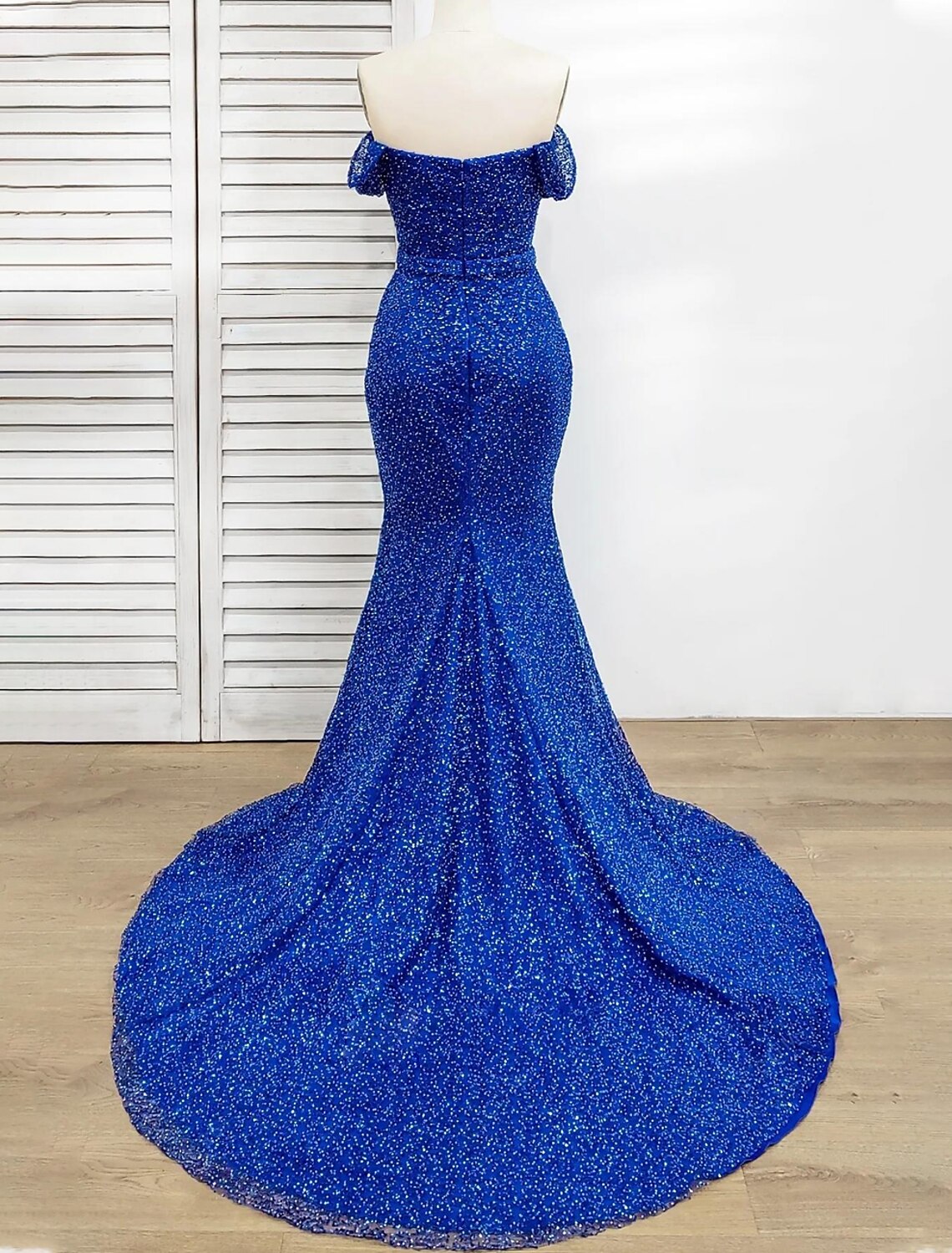 Back view of a sequined mermaid trumpet evening gown, showcasing the floor-length silhouette.