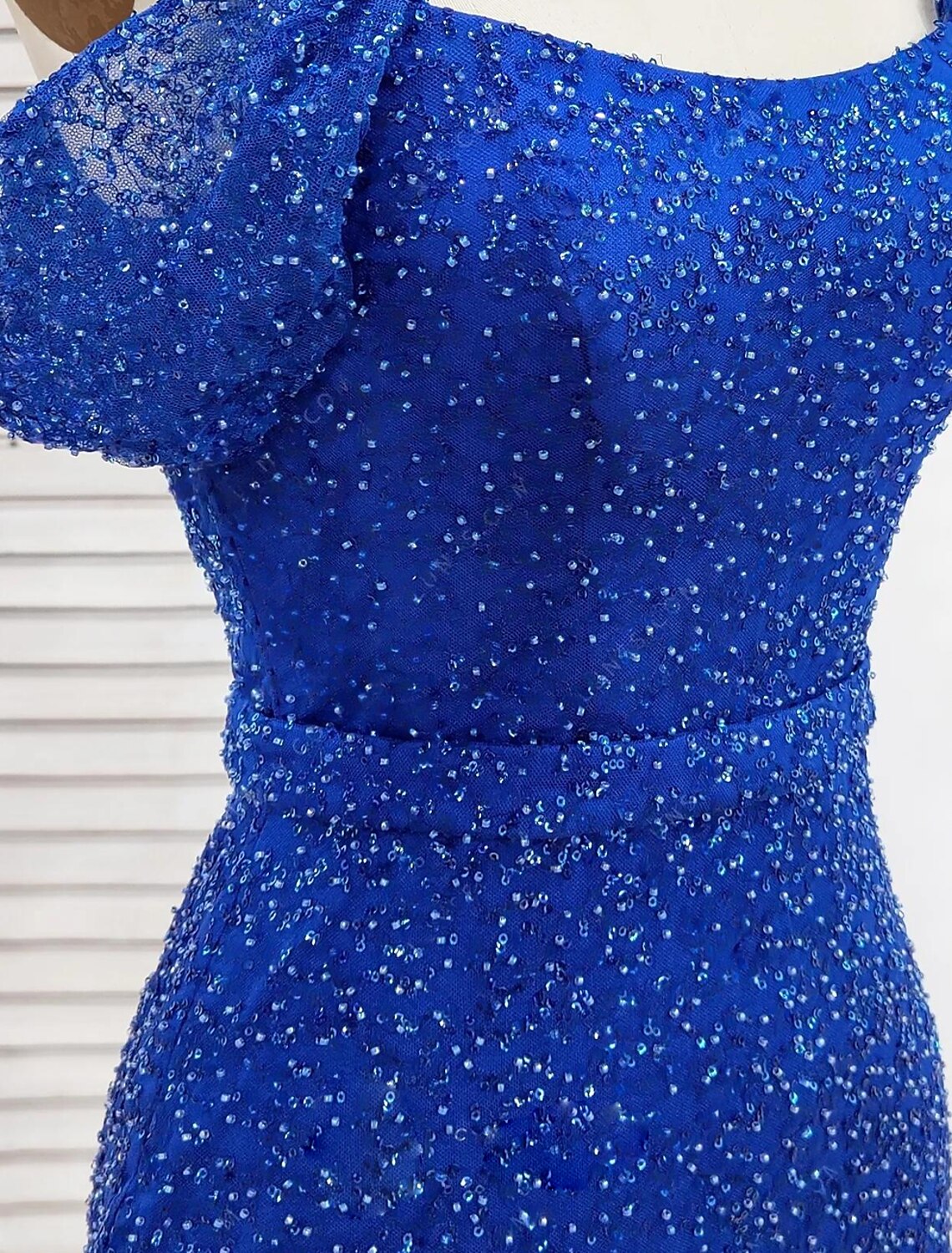 Side view of a woman wearing a sequined off-shoulder short sleeve evening gown.