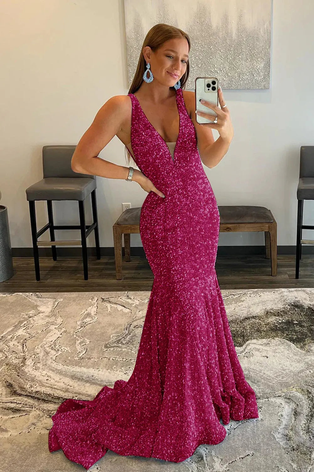 Model wearing an elegant sequined mermaid prom dress with a V-neck and backless design.