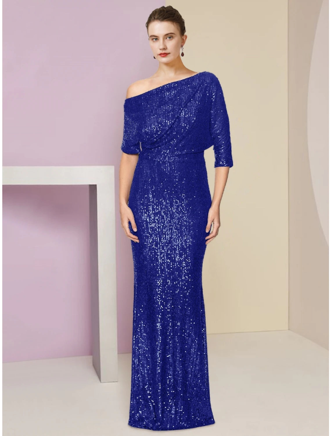 Woman wearing a sparkling navy blue sequined off-shoulder sheath Mother of the Bride dress.