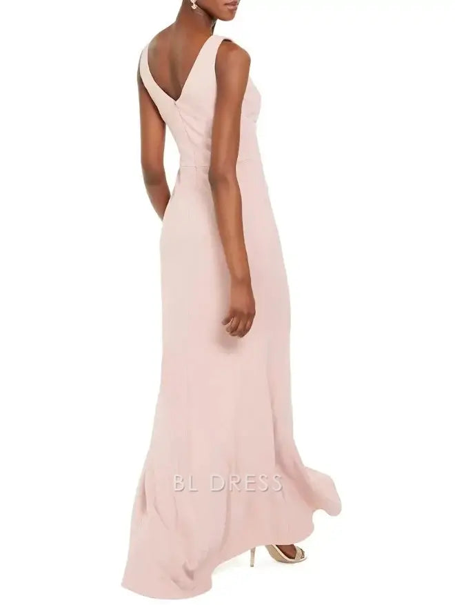 Side view of a woman in a sleeveless formal dress with pleated details.