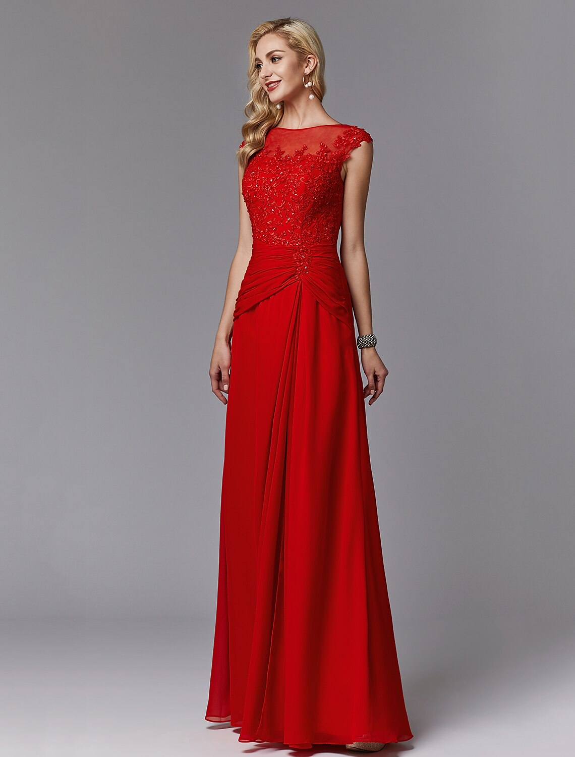Back view of the floor-length sheath dress showing pleats and illusion detail.
