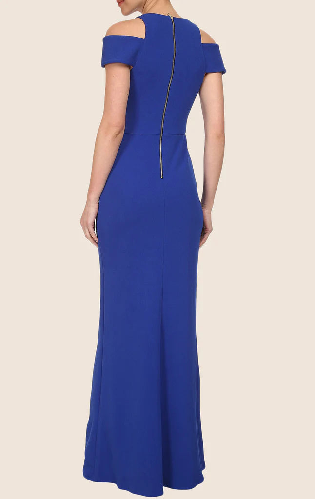 Back view of a woman in a sheath cap sleeve formal dress.