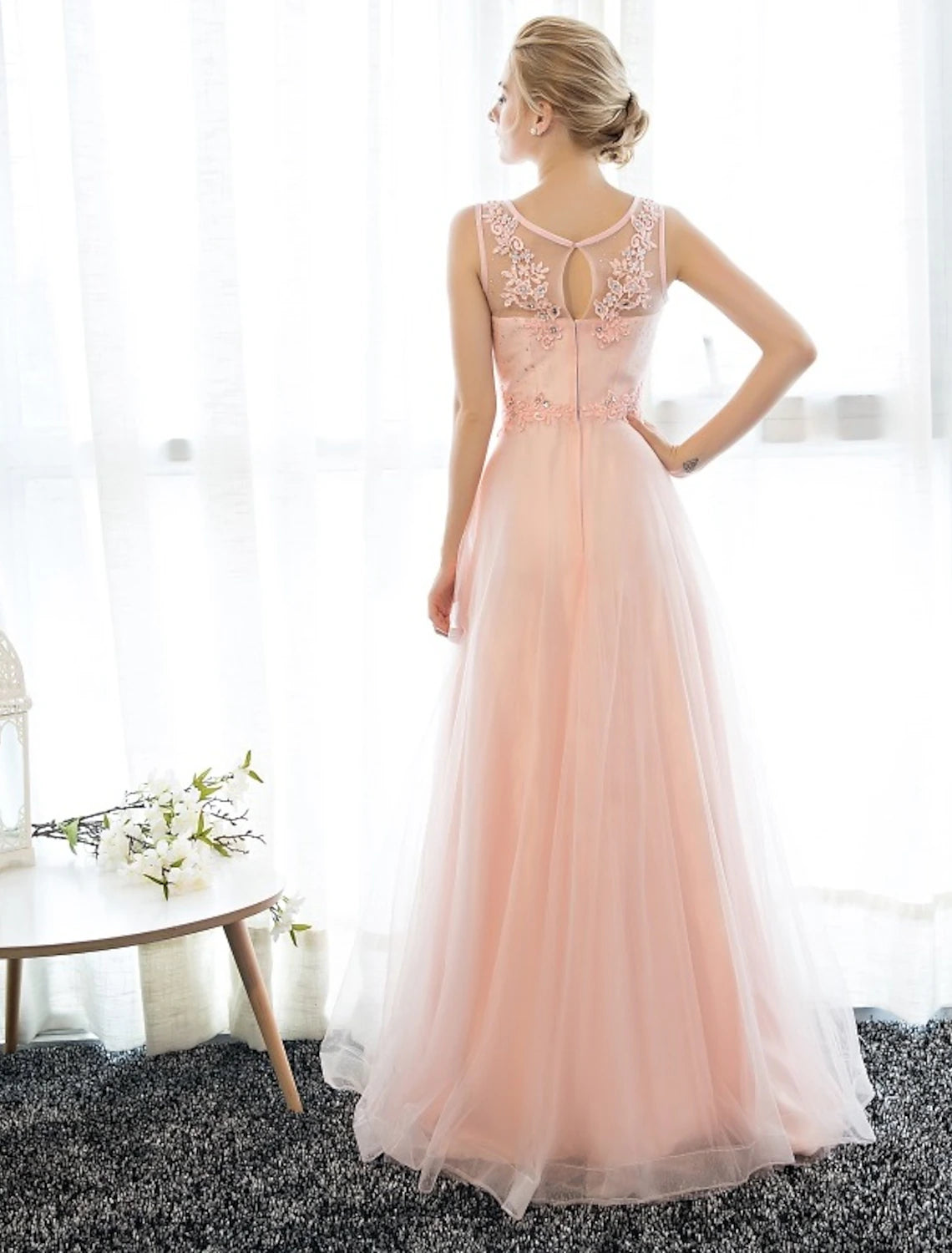 Back view of floor-length satin sheath dress with subtle detailing.