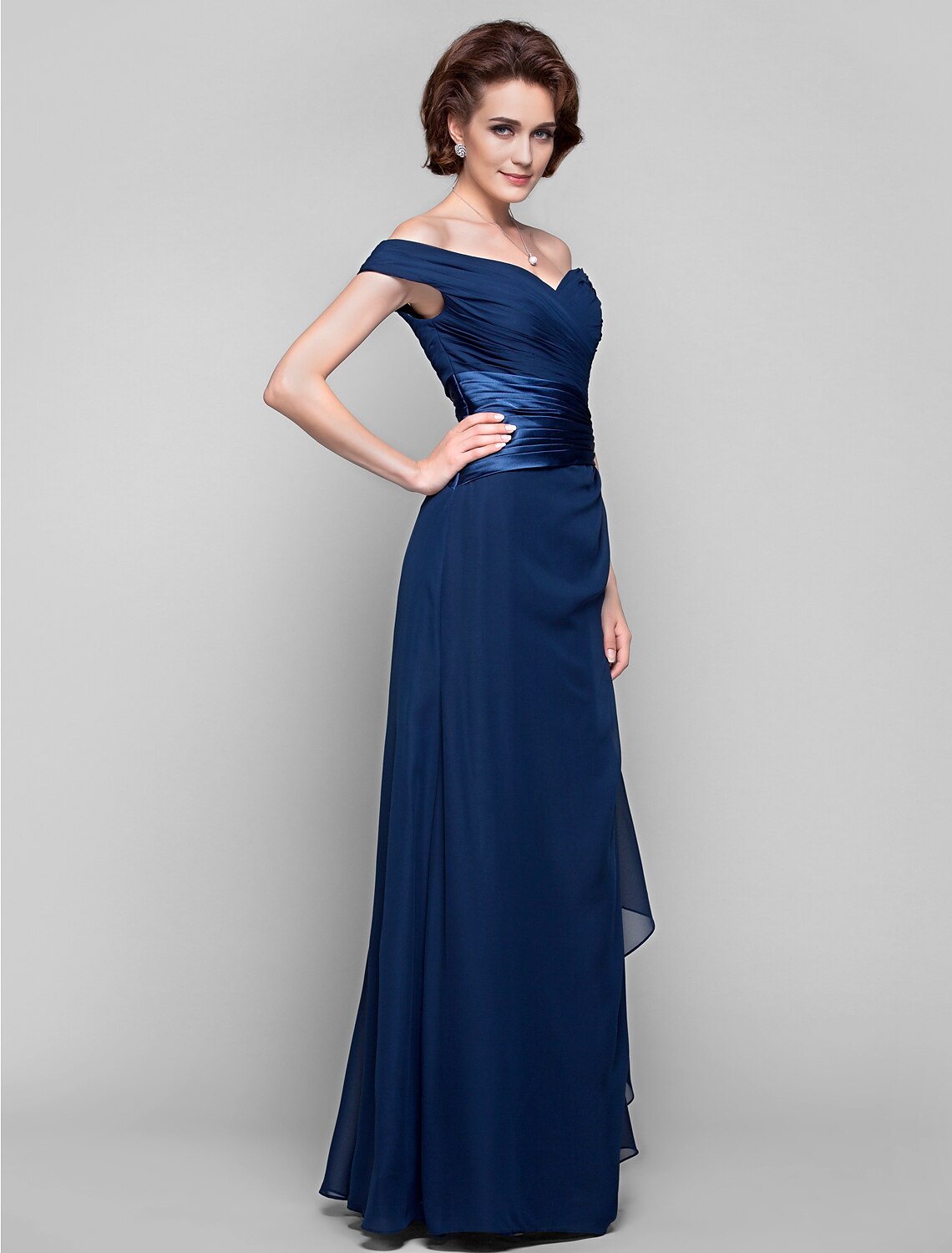 Back view of a dark blue off-shoulder sheath column dress with criss-cross detailing.