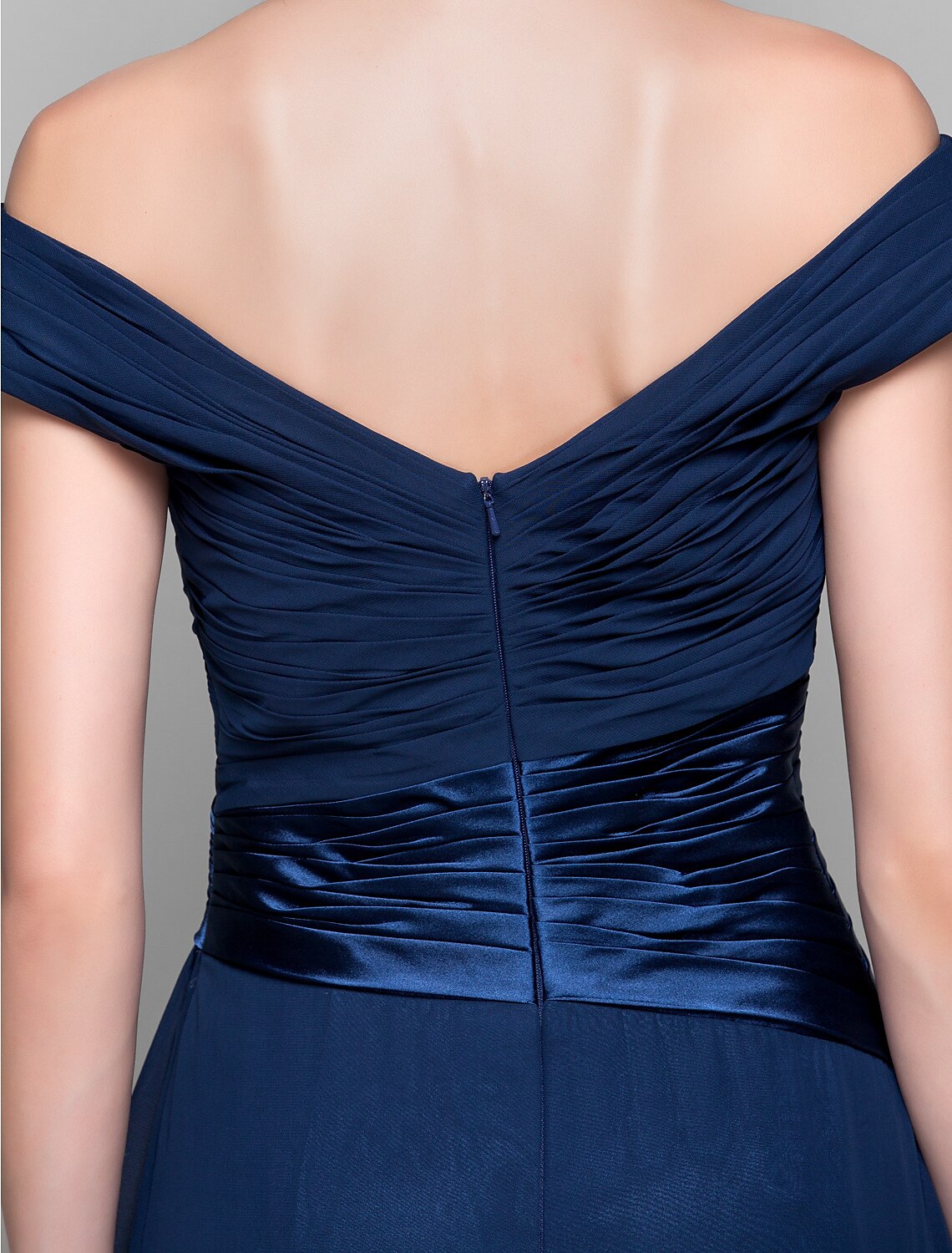 Detailed view of the chiffon fabric and drape of a dark blue dress.