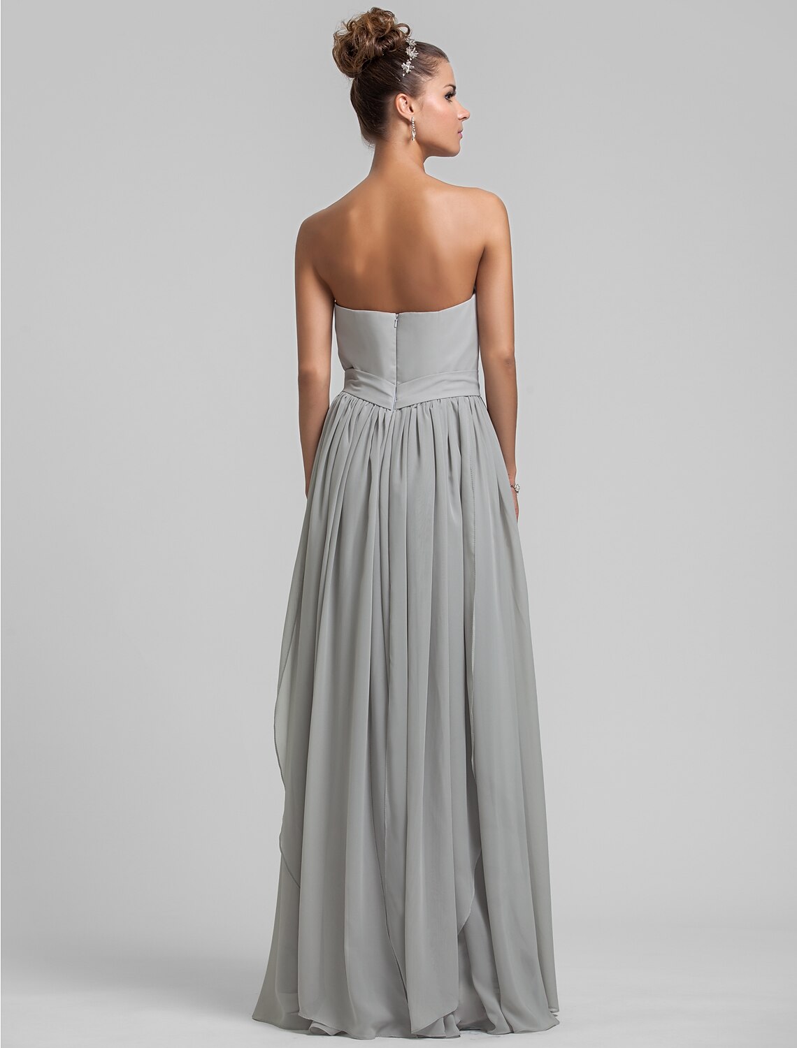 Side view of the draped chiffon gown with tassel detail.