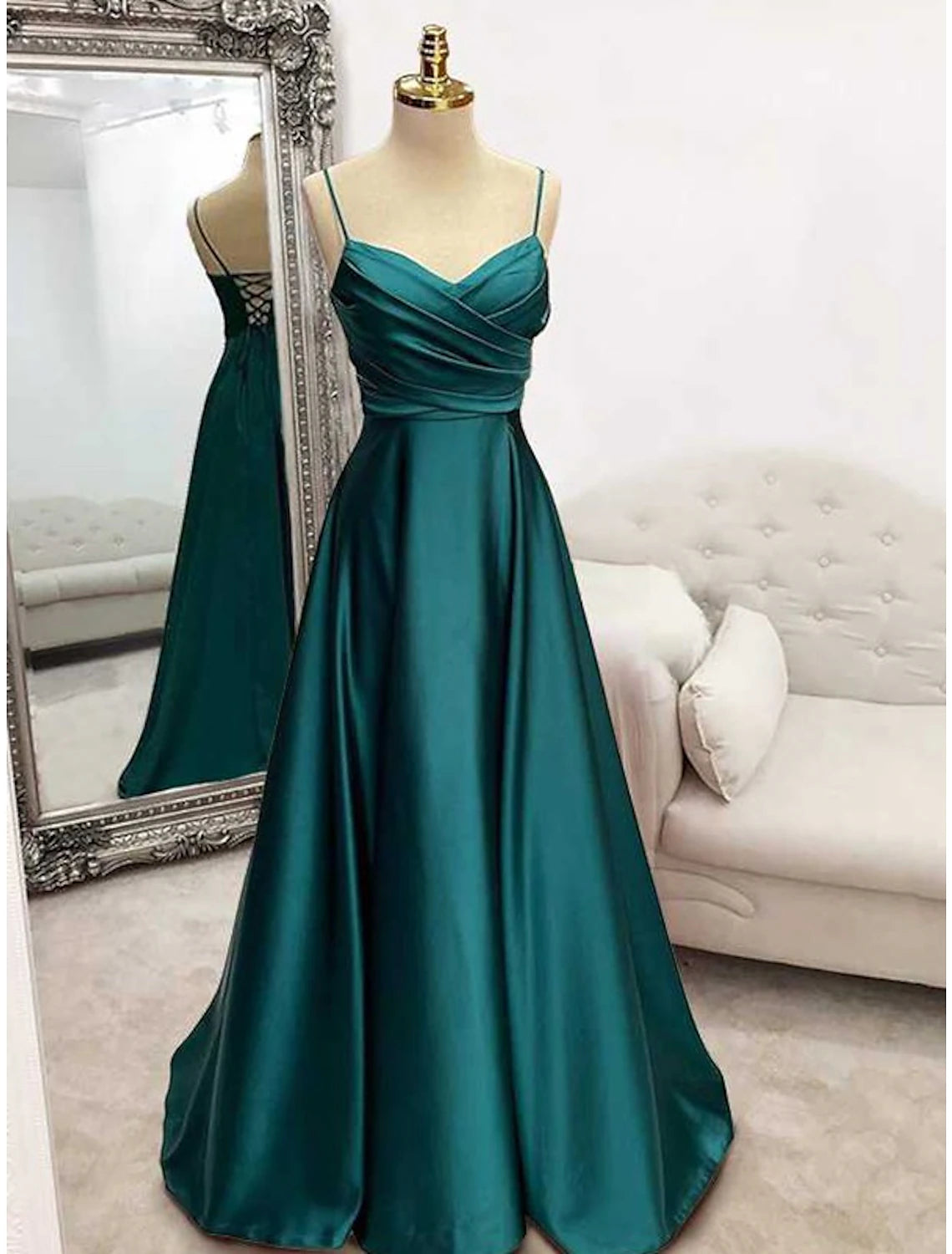 Woman wearing a dark floor-length sheath evening gown with spaghetti straps and a crisscross back.