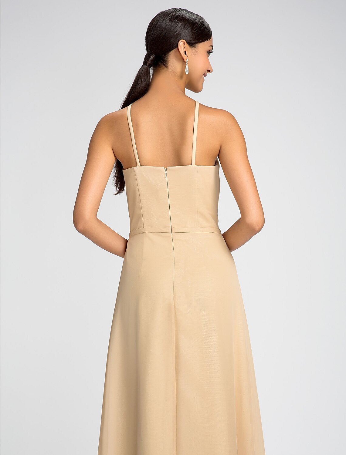 Full length view of a bridesmaid in a high neck chiffon dress.