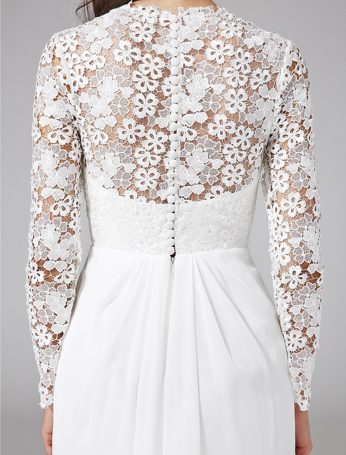 Bride posing in an elegant long sleeve wedding dress.