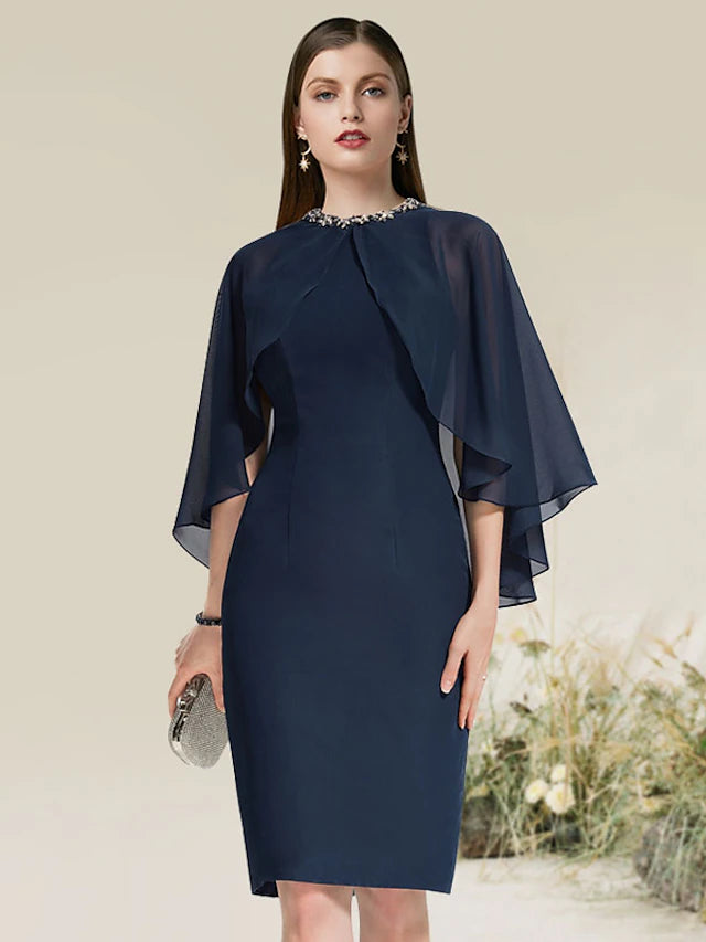 Black sheath cocktail dress with jewel neck and half sleeves, adorned with beading.